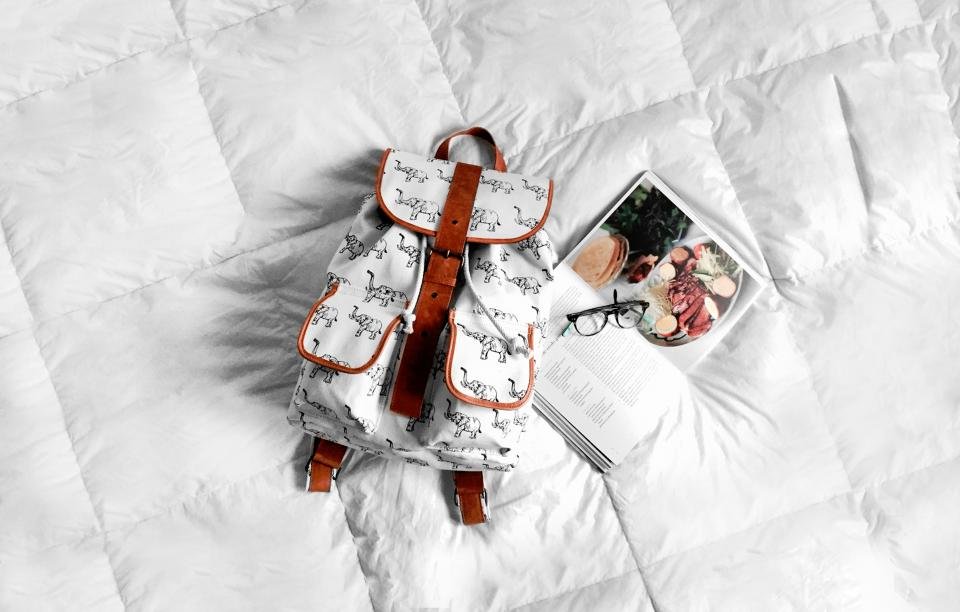 Sac NOMAD 25L posé à plat avec des accessoires