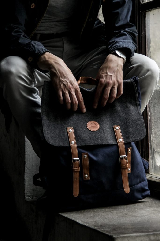 Homme assis, sac NOMAD 25L sur les genoux